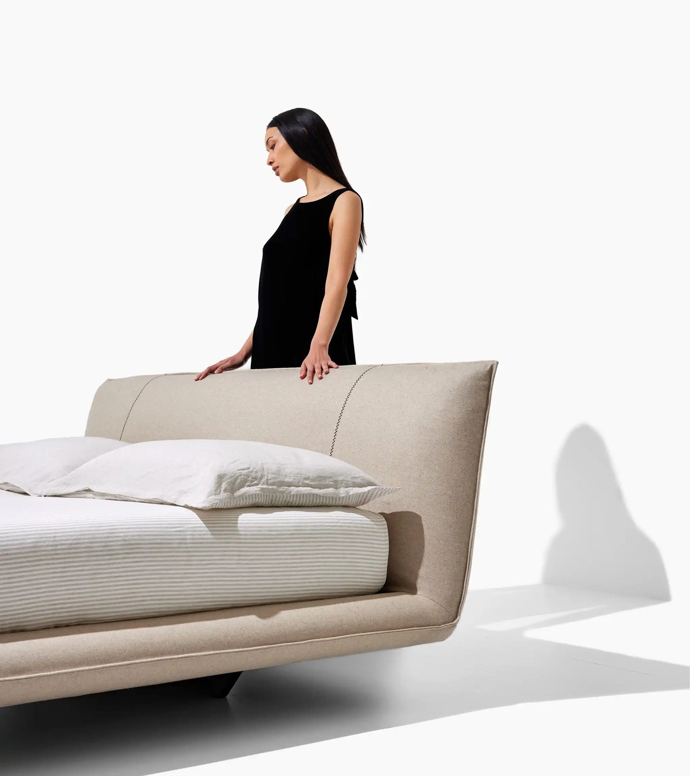 Letto Alto con testiera imbottita in tessuto beige e cuciture a vista