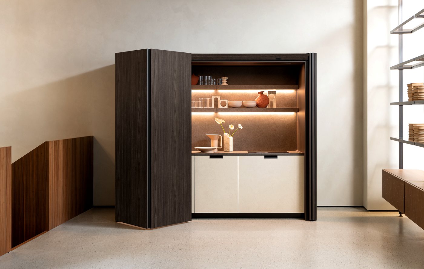 Cucina Euromobil a scomparsa con ante a libro in legno scuro e mensole illuminate